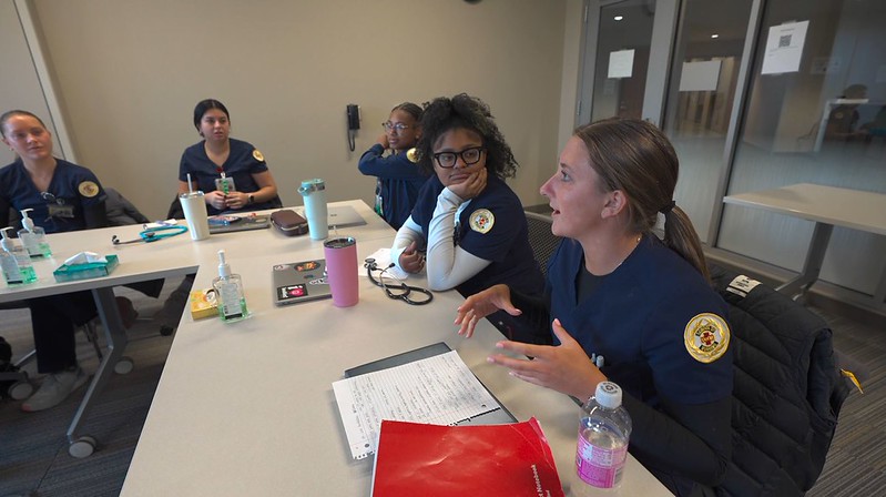 Students discussing topics in classroom around a table