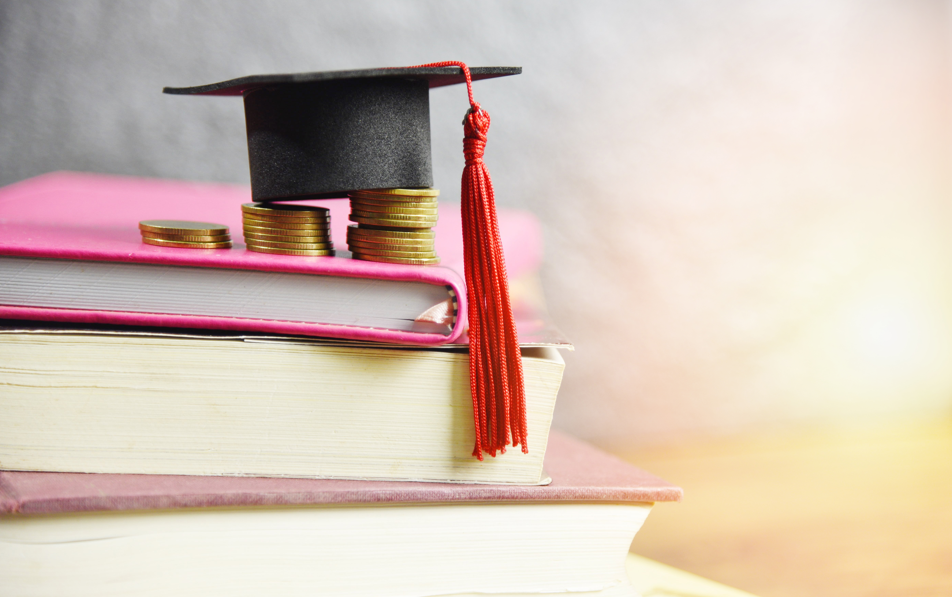 Books stacked with graduation cap on top