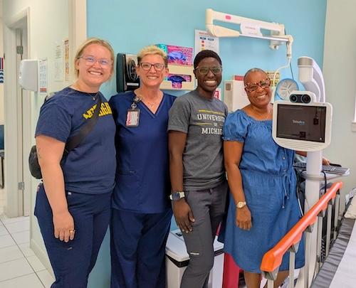 Students and faculty using telemedicine equipment in a clinic, collaborating to advance global education, research, and healthcare in diverse communities.